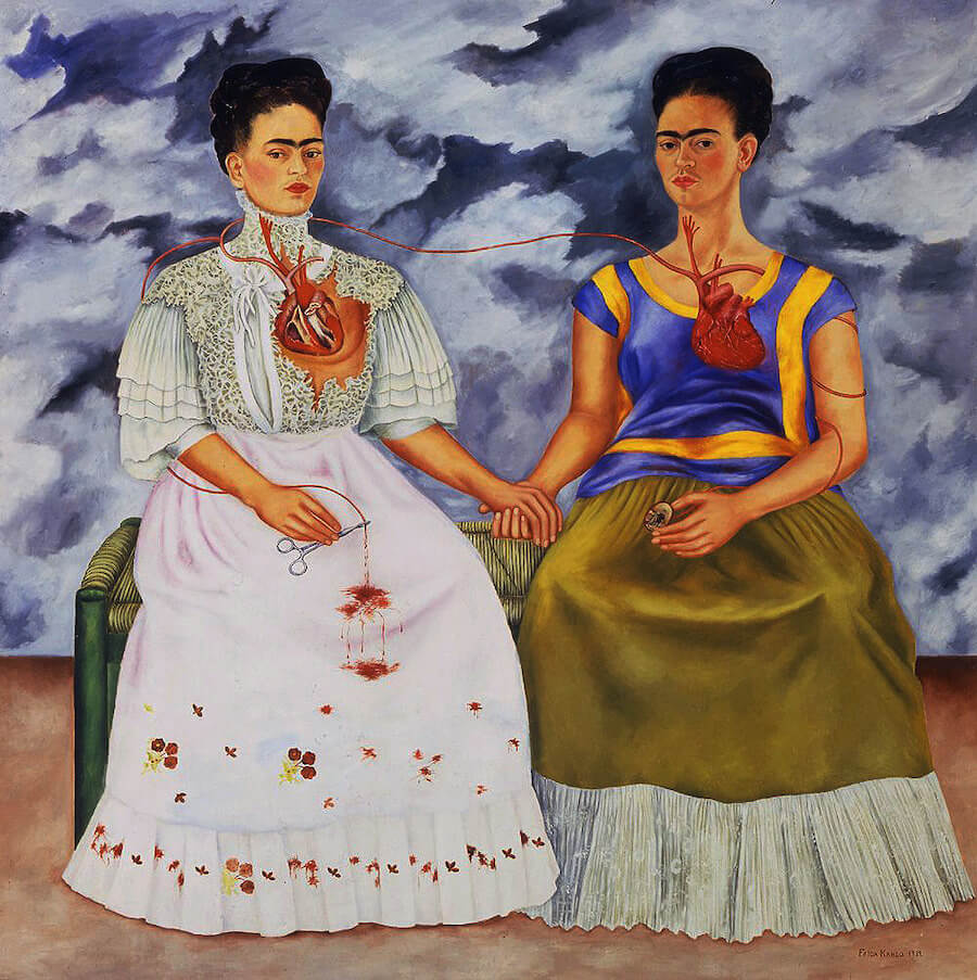 Frida Kahlo's 'The Two Fridas' painting - a double self-portrait illustrating the artist's European and Mexican identities and emotional duality, set against a stormy sky background.
