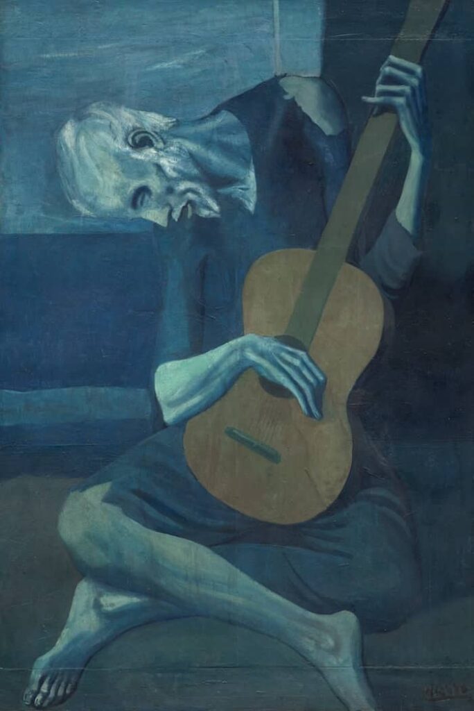 Pablo Picasso's 'The Old Guitarist' from his Blue Period, depicting an emaciated elderly man, enveloped in shades of blue, playing a brown guitar.